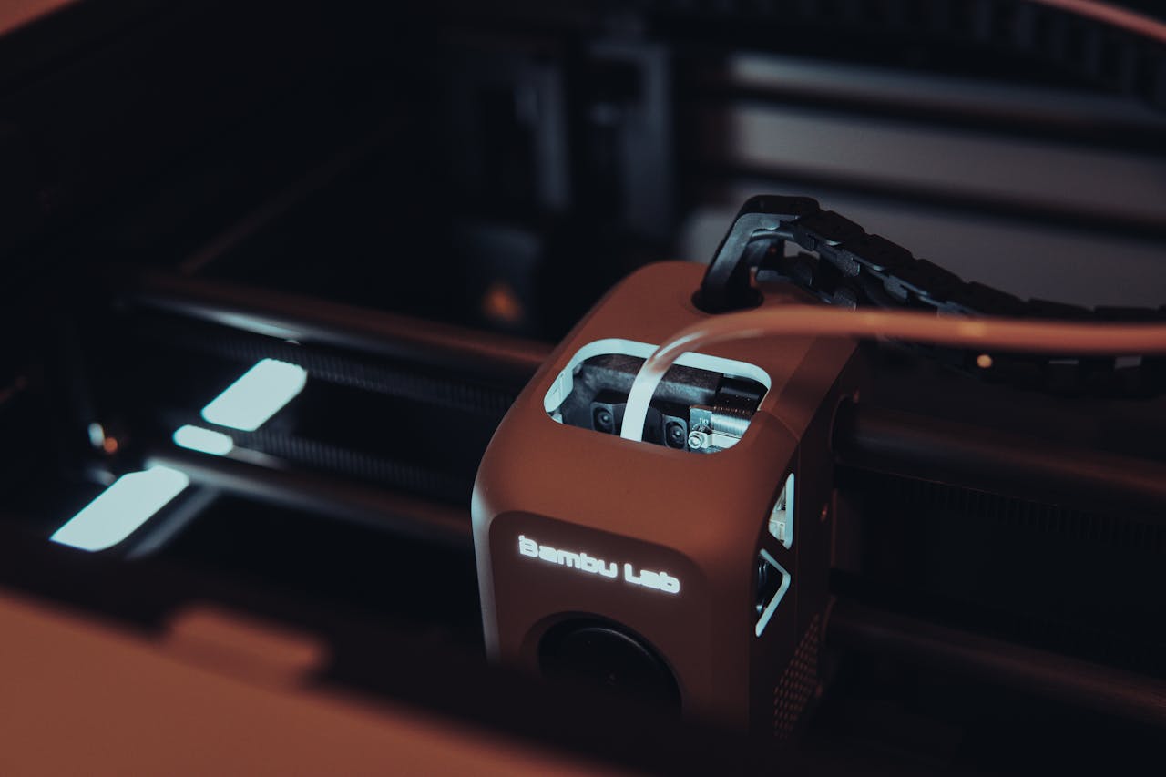 Detailed view of a 3D printer mechanism in a dark setting, highlighting technology.